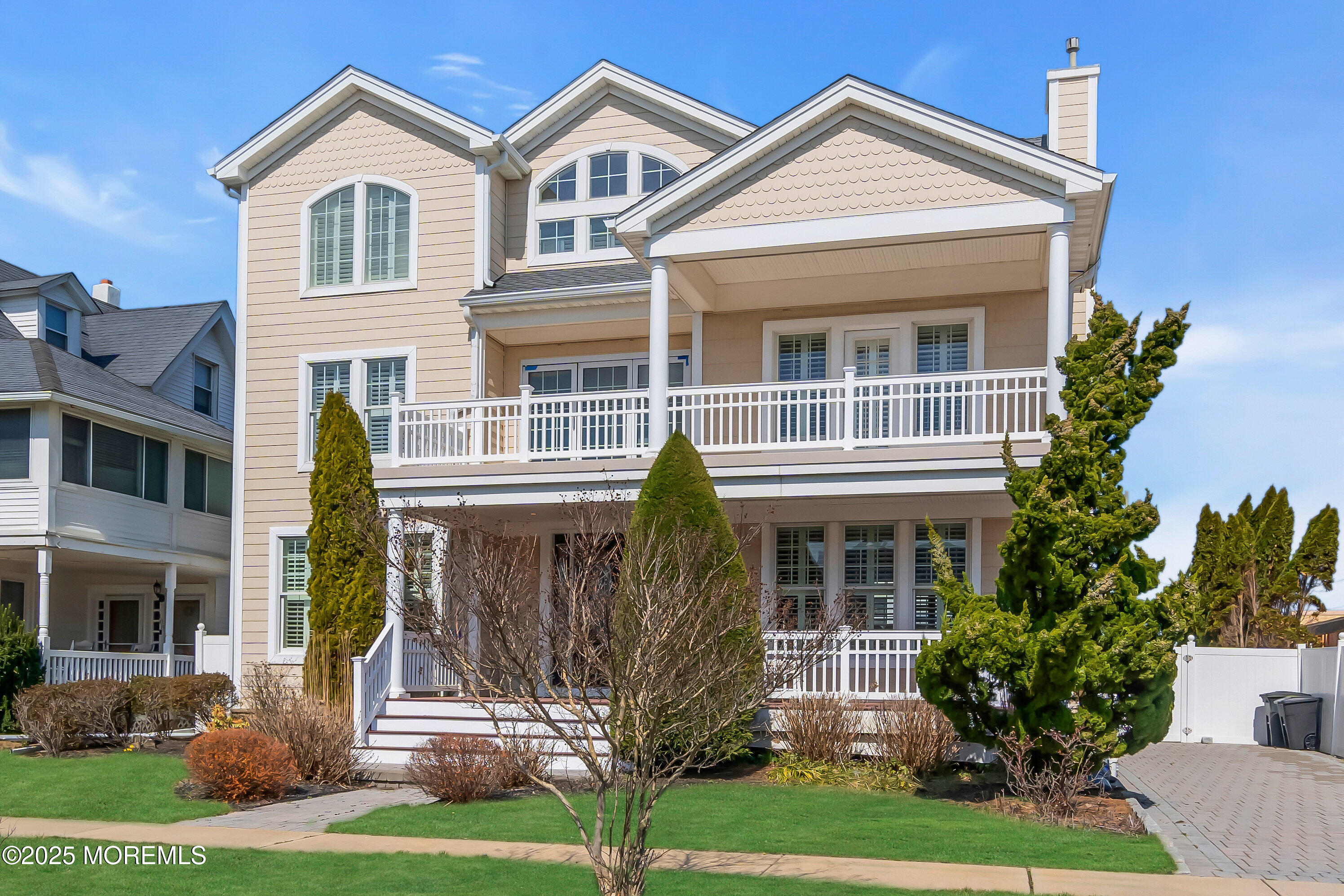 106 2nd Avenue Belmar, NJ 07719 - Photo 1 of 42 a view of a white house with large windows and a yard with plants and large trees