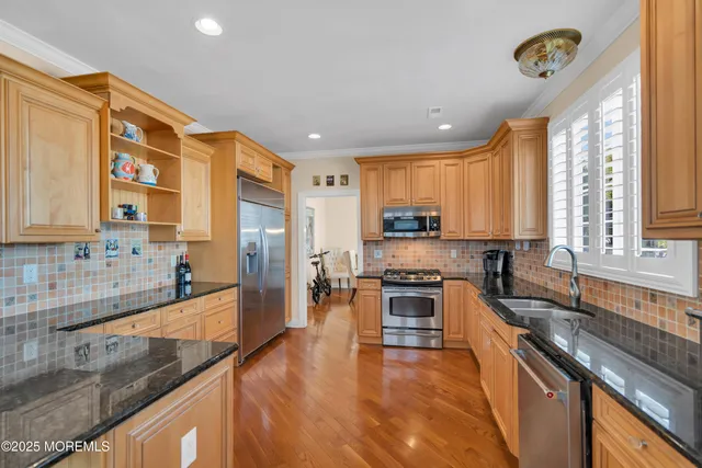 a kitchen with stainless steel appliances granite countertop sink stove top oven and cabinets