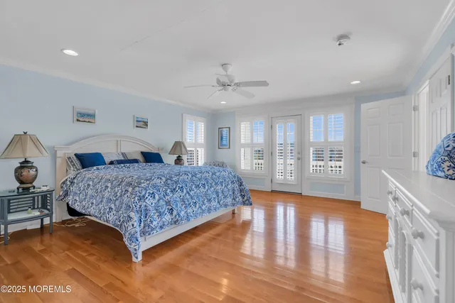 a bedroom with a large bed and wooden floor