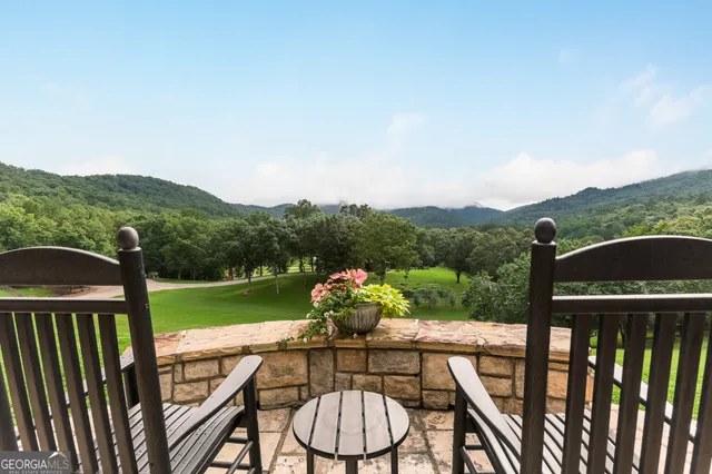 a bedroom with a bed a dresser and a large window with wooden floor