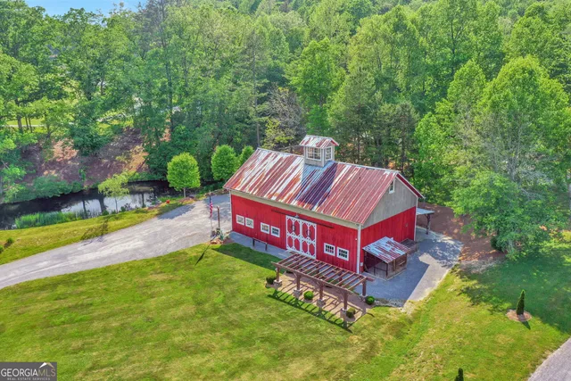 an aerial view of residential houses with outdoor space and trees