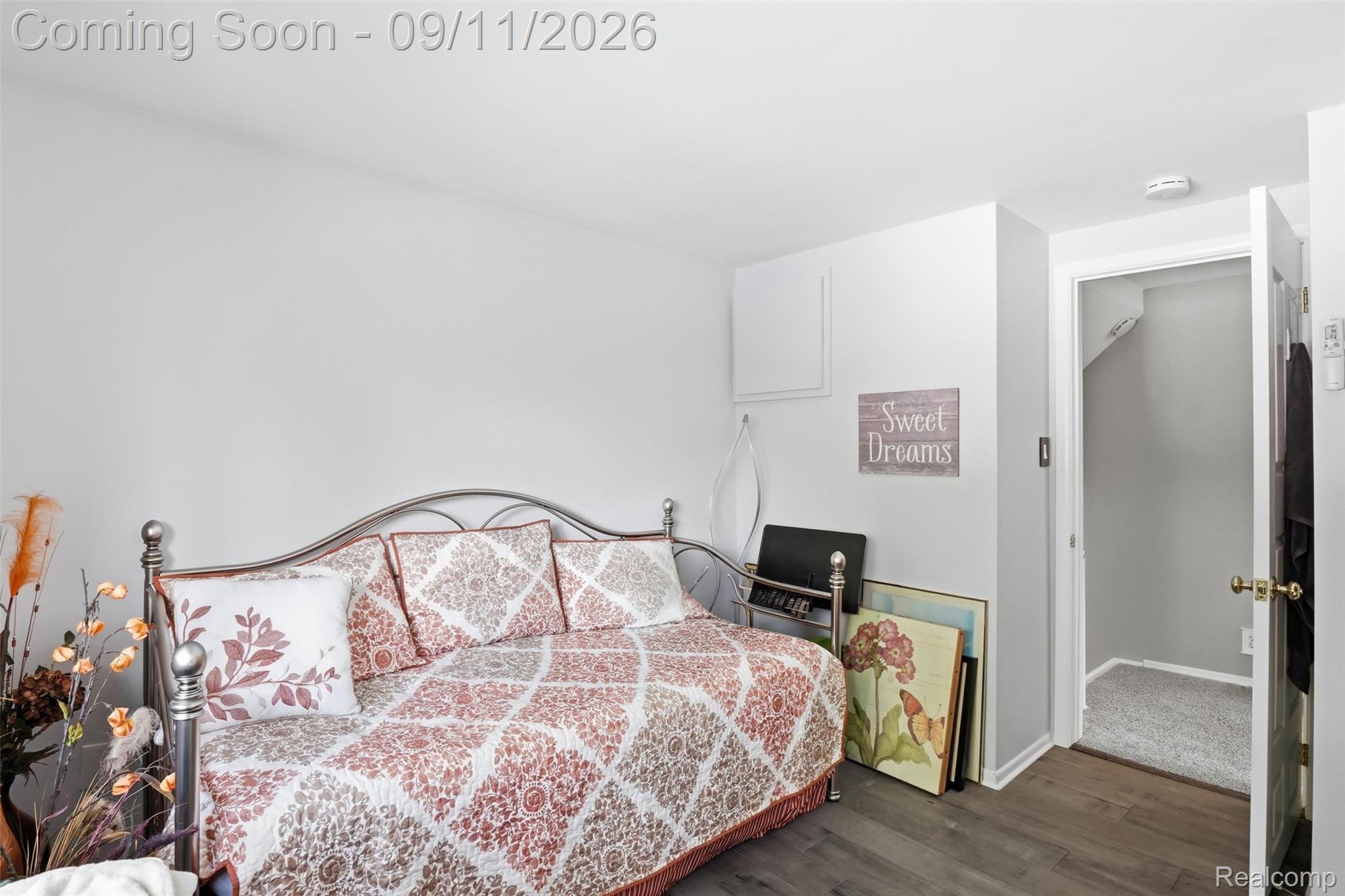 16799 Farmington Road Livonia, MI 48154 - Photo 24 of 71 Hardwood-finish flooring, white painted walls, and a visible doorway with a grey carpeted interior