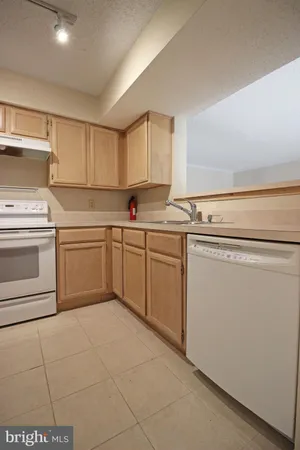a kitchen with a stove sink and cabinets