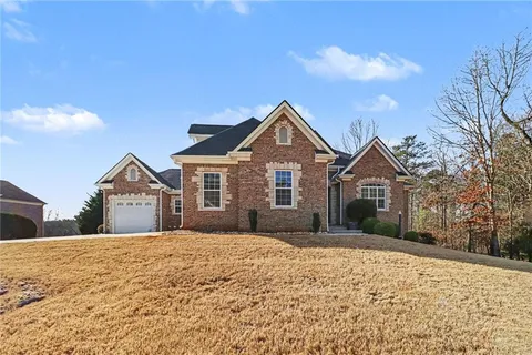 a front view of a house with a yard covered in snow