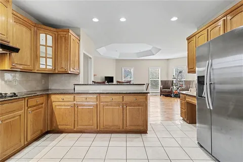 a kitchen with stainless steel appliances granite countertop a refrigerator a stove and a sink