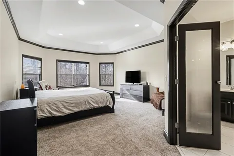 a spacious bedroom with a bed and a flat screen tv