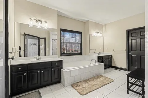a bathroom with a tub sink shower and a mirror