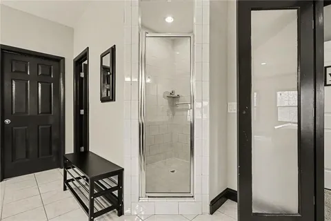 a bathroom with a glass shower door a sink and a mirror