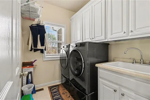 a bathroom with a sink and a washing machine with a mirror