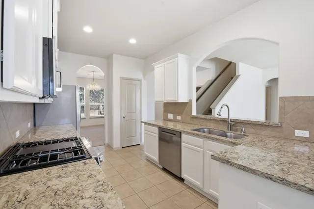 a kitchen with granite countertop a stove and a sink