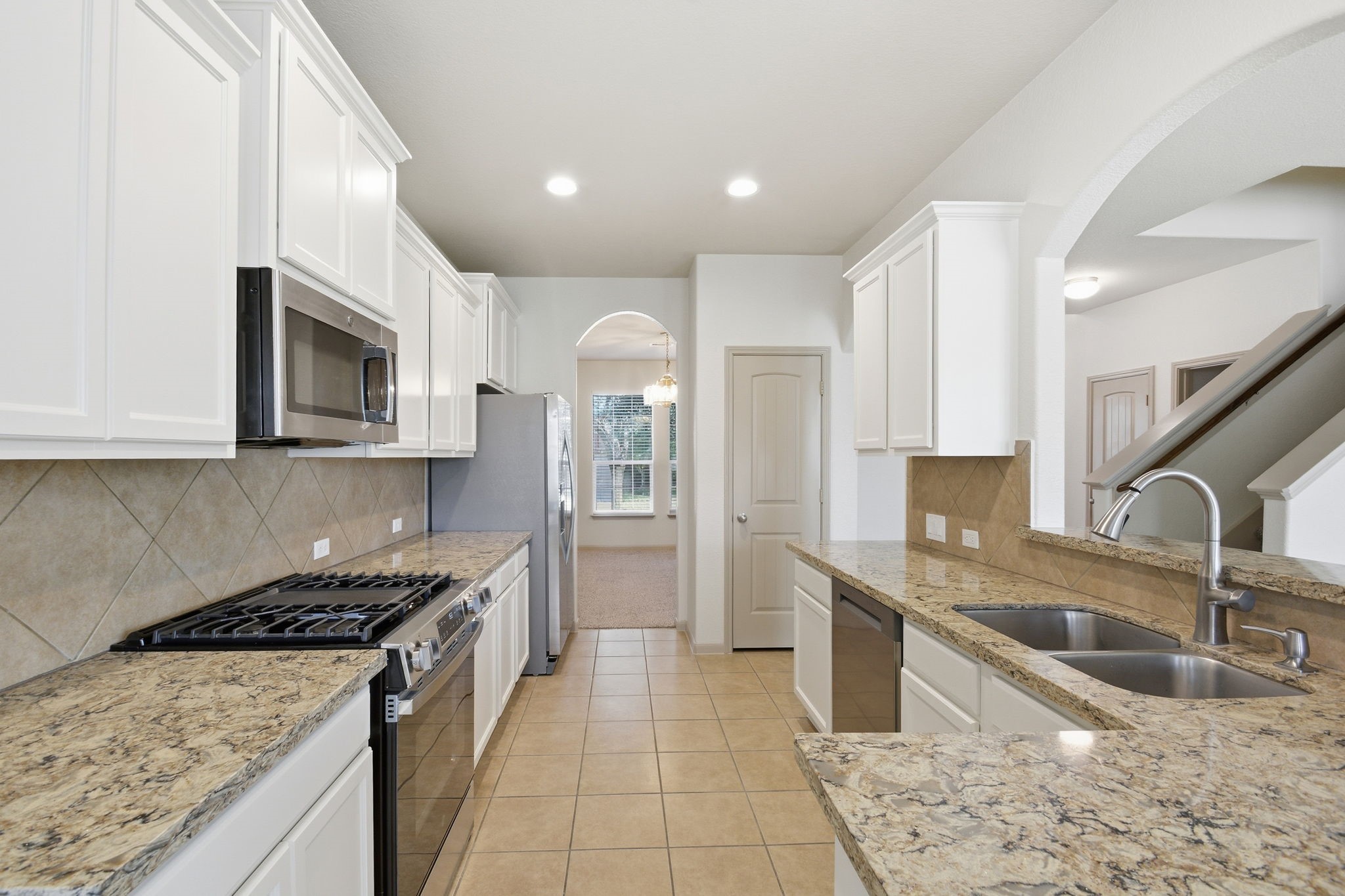 25523 Marmite Drive Tomball, TX 77375 - Photo 20 of 50 a kitchen with stainless steel appliances granite countertop a sink stove and cabinets