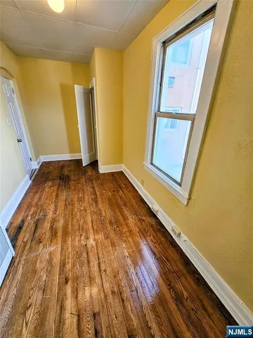a view of a room with wooden floor and door