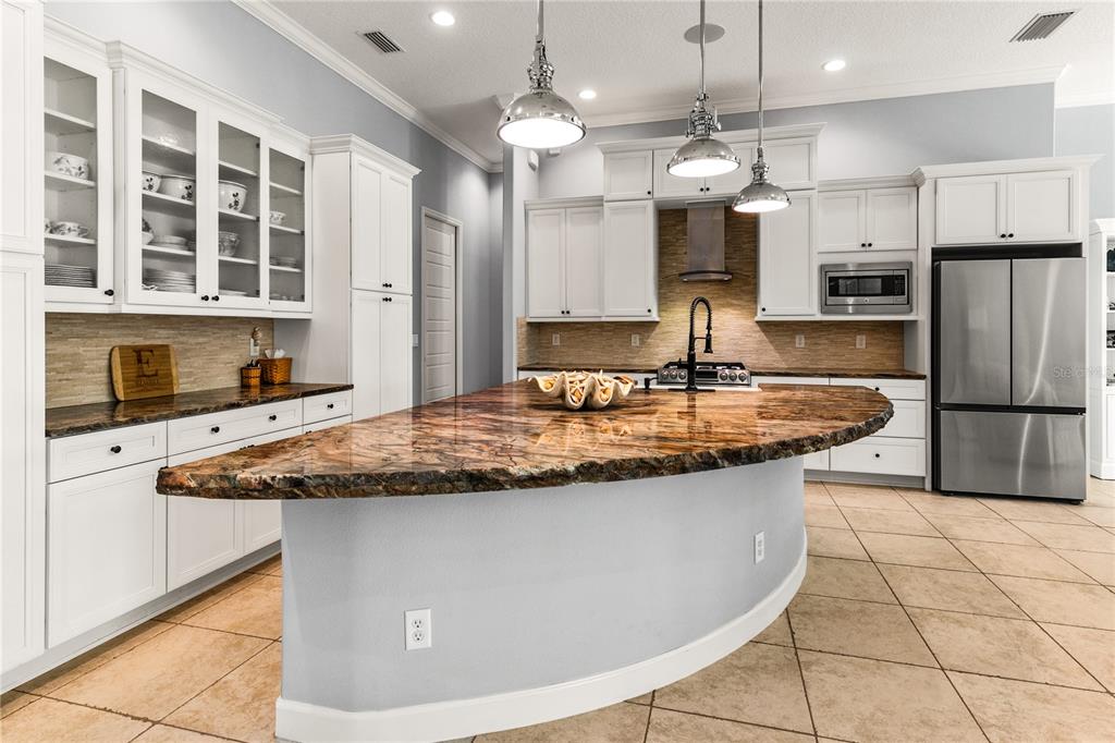 8065 Bridgeport Bay Circle Mount Dora, FL 32757 - Photo 11 of 60 a kitchen with stainless steel appliances granite countertop a sink a stove a refrigerator and cabinets