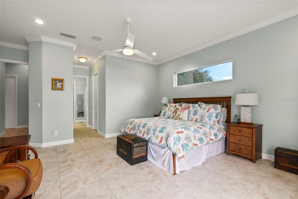 8065 Bridgeport Bay Circle Mount Dora, FL 32757 - Photo 20 of 60 a bedroom with a bed and a chandelier