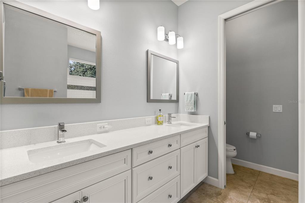 8065 Bridgeport Bay Circle Mount Dora, FL 32757 - Photo 24 of 60 a bathroom with a double vanity sink and a mirror