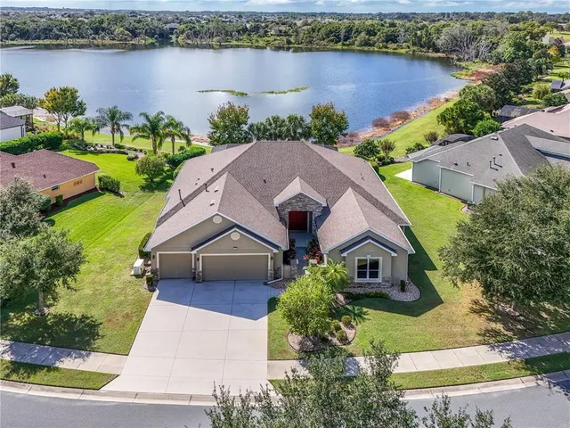 an aerial view of a house with a garden and lake view