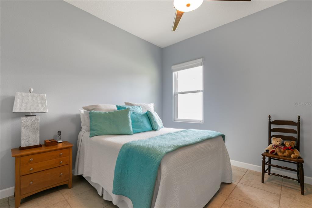 8065 Bridgeport Bay Circle Mount Dora, FL 32757 - Photo 35 of 60 a bedroom with a bed and a chair