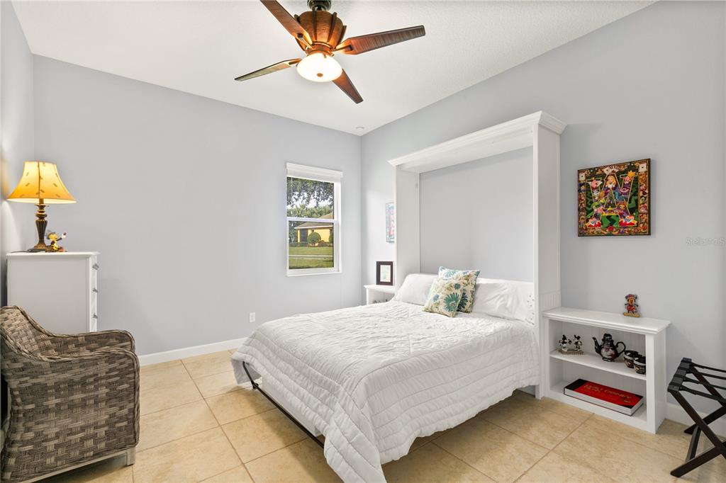 8065 Bridgeport Bay Circle Mount Dora, FL 32757 - Photo 37 of 60 a bedroom with a bed and a chandelier