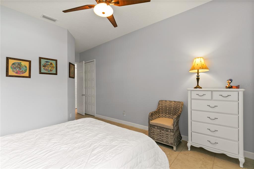 8065 Bridgeport Bay Circle Mount Dora, FL 32757 - Photo 38 of 60 a bedroom with a bed and a chandelier