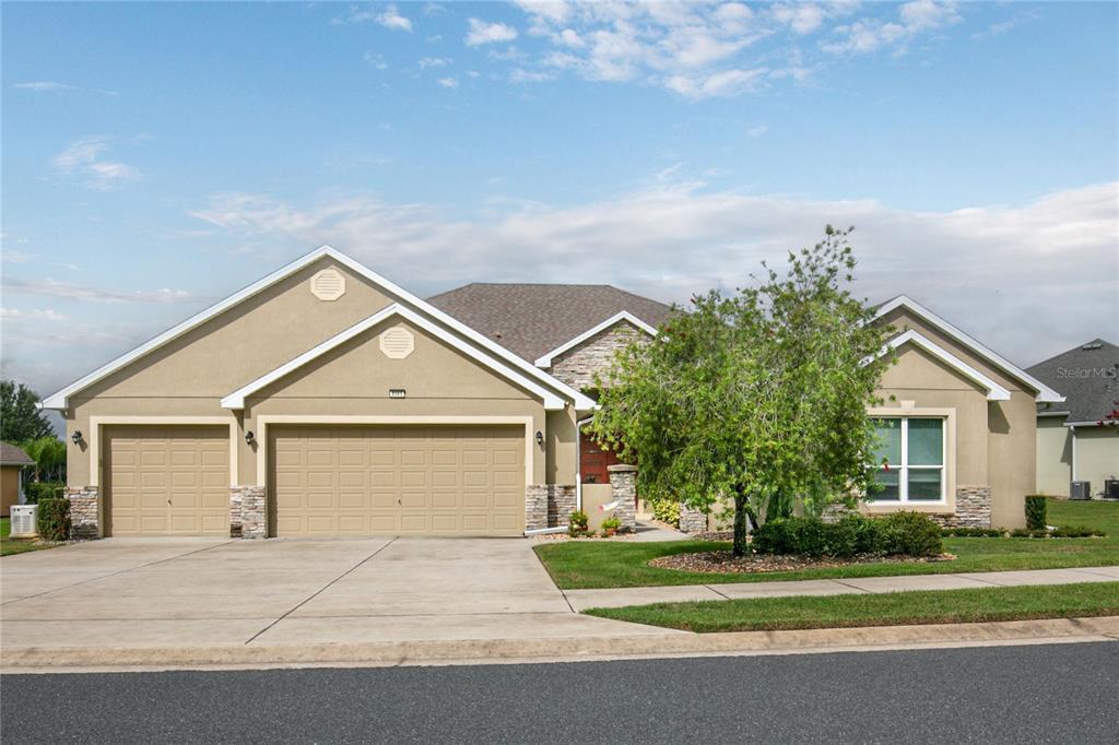 8065 Bridgeport Bay Circle Mount Dora, FL 32757 - Photo 41 of 60 a front view of a house with a yard and garage