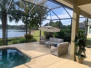 8065 Bridgeport Bay Circle Mount Dora, FL 32757 - Photo 10 of 60 a view of a patio with couches table and chairs under an umbrella