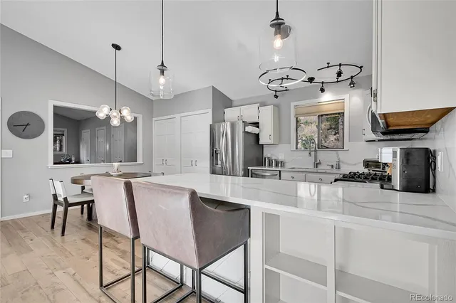 a kitchen with kitchen island granite countertop a sink a center island and cabinets