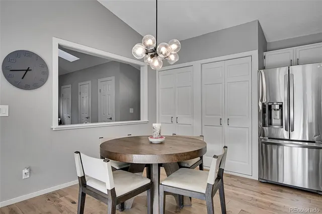 a view of a dining room with furniture a chandelier and wooden floor