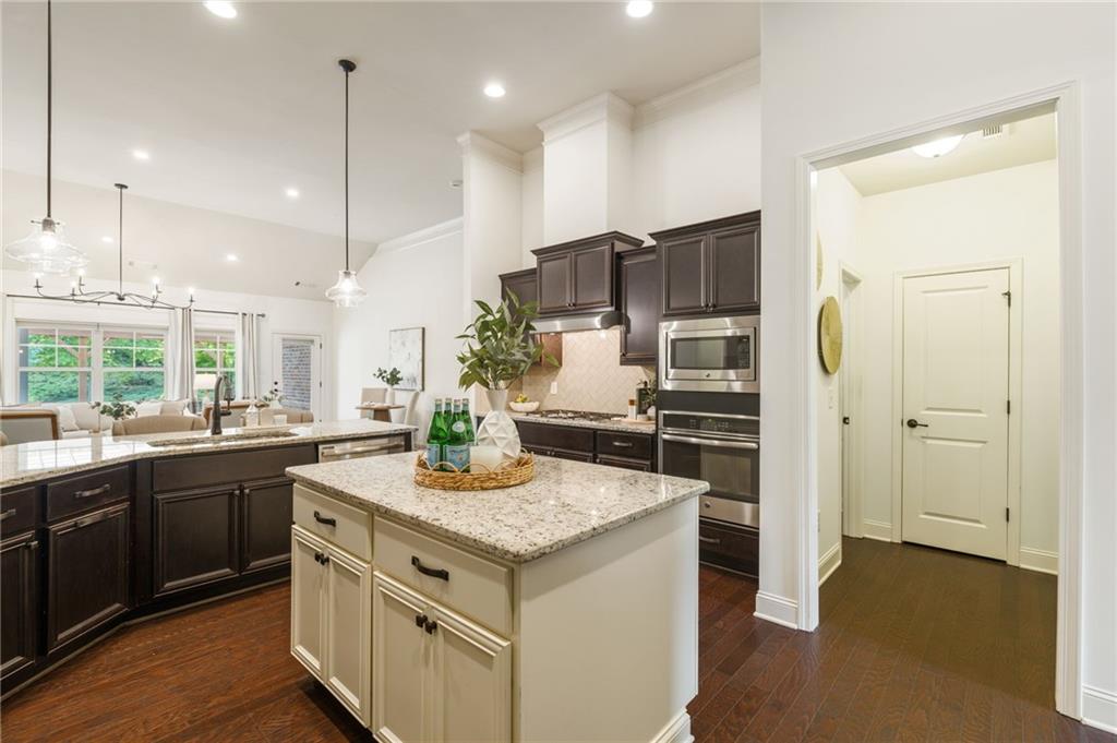 4735 Amble Trace Cumming, GA 30040 - Photo 38 of 73 a kitchen with stainless steel appliances granite countertop a sink a stove and a wooden floors
