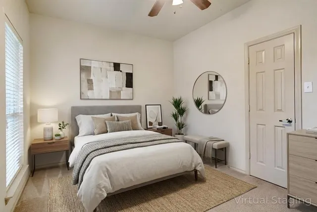 a bedroom with a bed a mirror and lamp