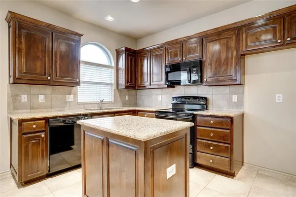 a kitchen with stainless steel appliances granite countertop a stove and cabinets