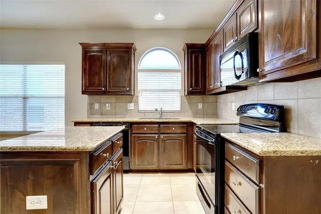 a kitchen with stainless steel appliances granite countertop a sink stove and cabinets