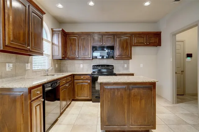 a kitchen with stainless steel appliances granite countertop a stove sink and cabinets