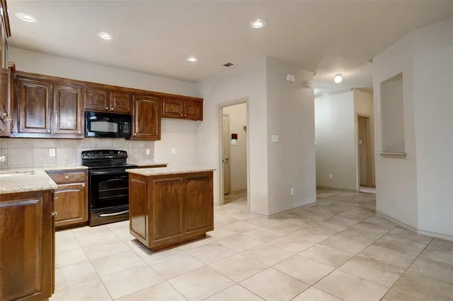 a kitchen with stainless steel appliances granite countertop a stove and a refrigerator