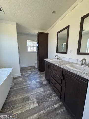 a spacious bathroom with a double vanity sink a mirror and a bathtub