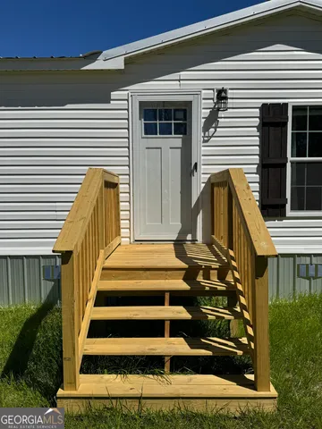a view of wooden house with a small yard
