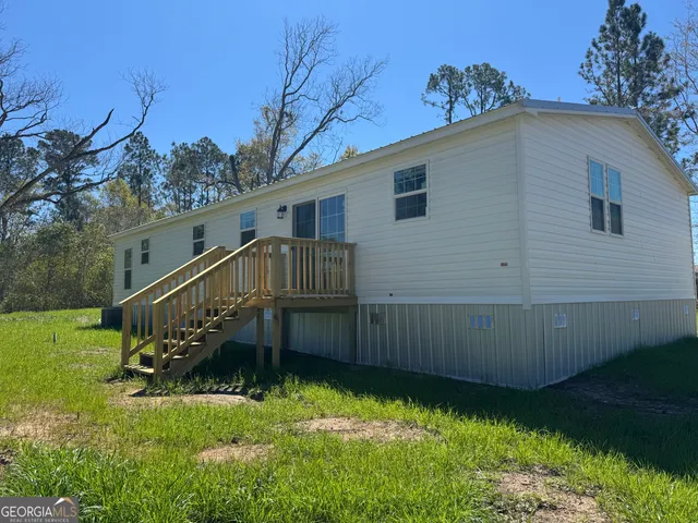 a view of backyard with deck and garden