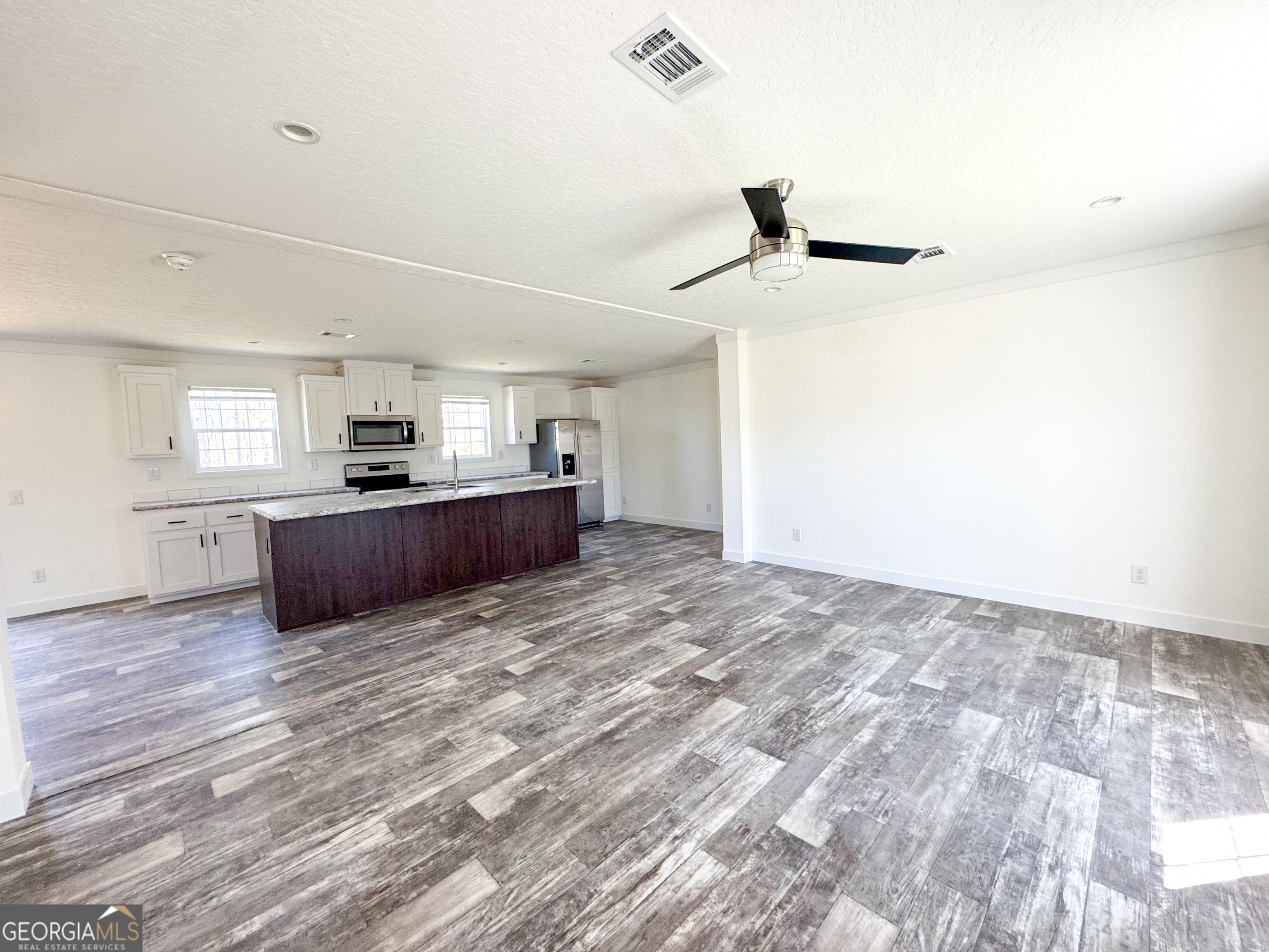 1505 West 4th St Extension Alma, GA 31510 - Photo 4 of 22 a view of a kitchen with a stove cabinets and wooden floor