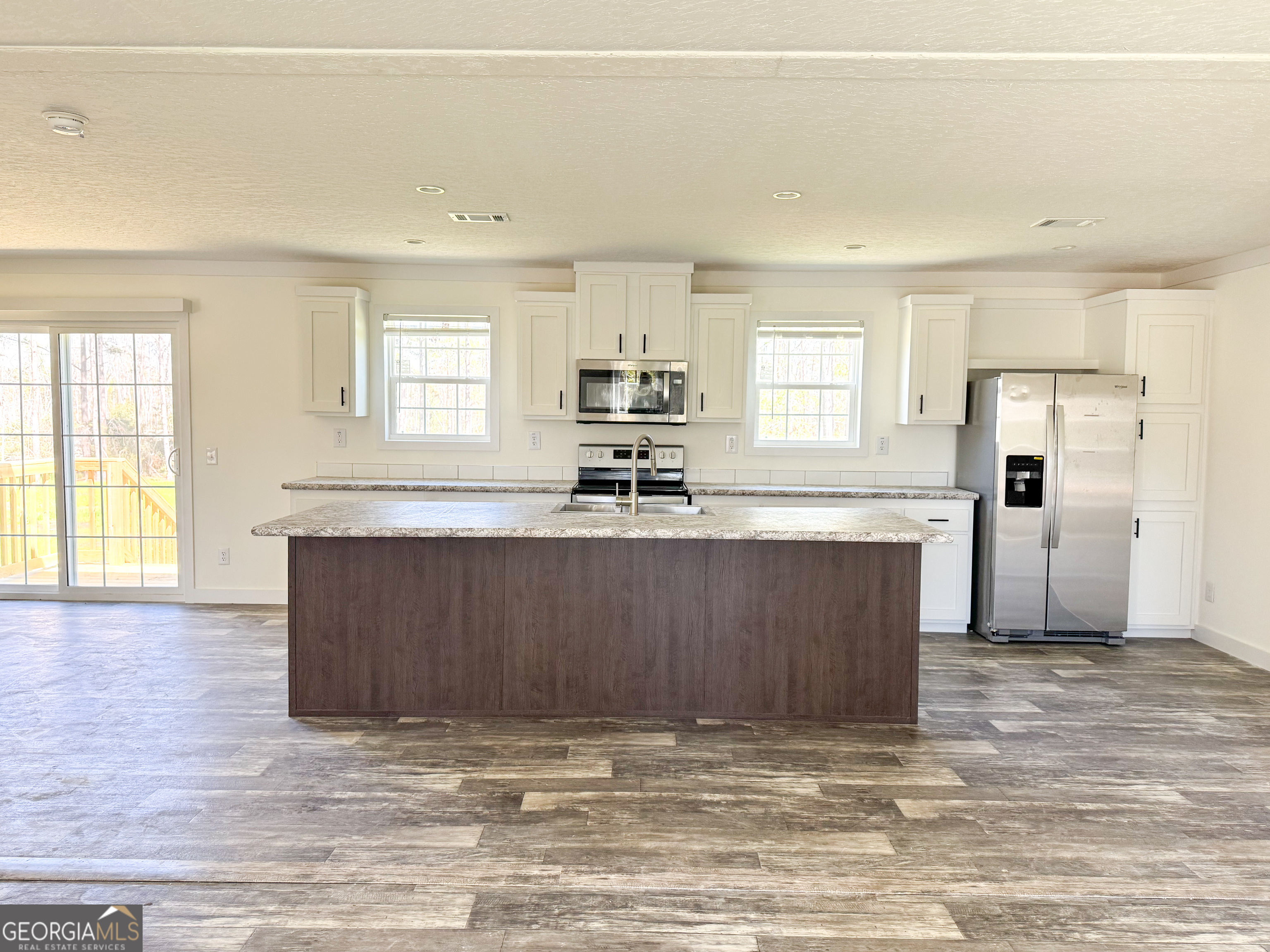 1505 West 4th St Extension Alma, GA 31510 - Photo 5 of 22 a view of kitchen with granite countertop cabinets and refrigerator