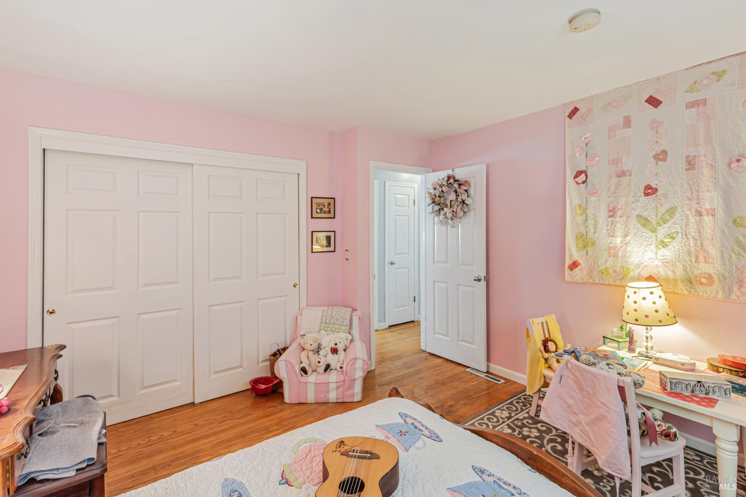 3590 Burnside Road Sebastopol, CA 95472 - Photo 26 of 69 a bedroom with a bed and wooden floor