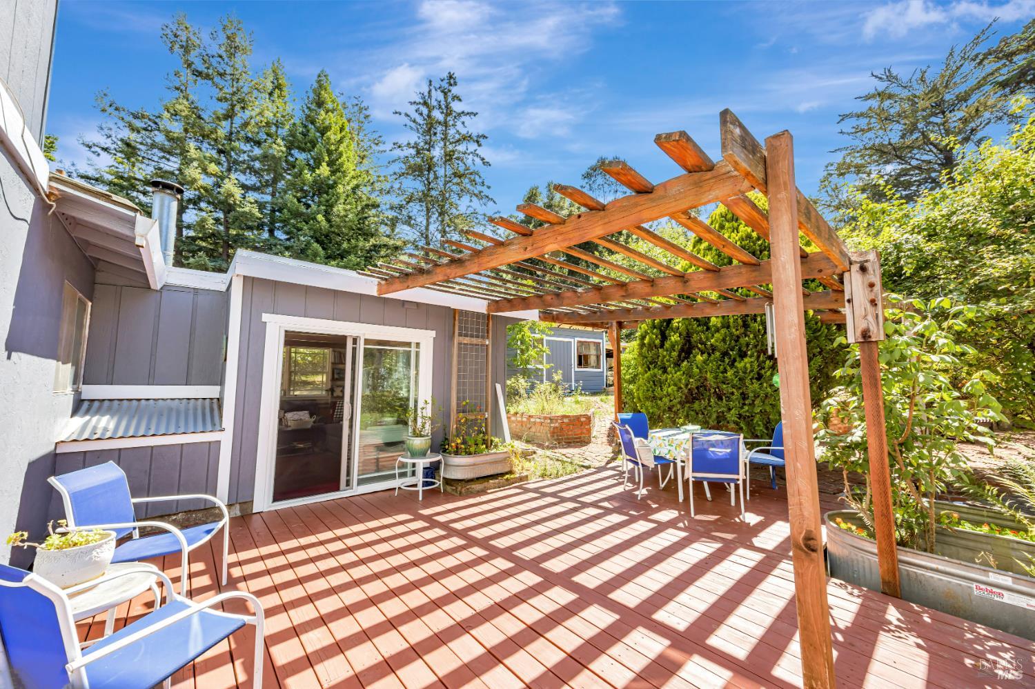 3590 Burnside Road Sebastopol, CA 95472 - Photo 40 of 69 a view of a patio with table and chairs potted plants and floor to ceiling window