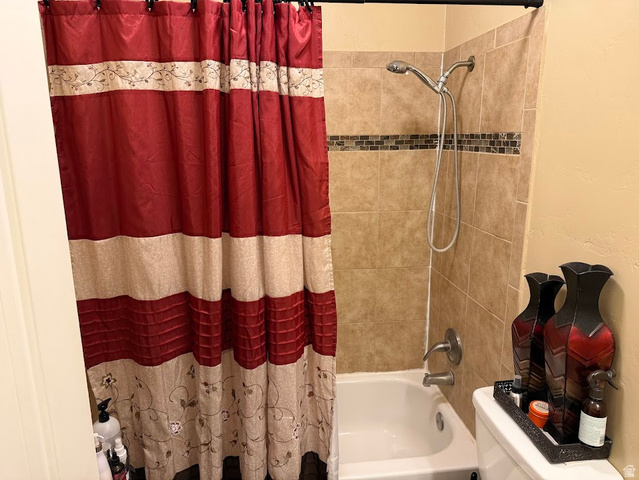 737 Wasatch Street Midvale, UT 84047 - Photo 7 of 29 Bathtub with a tiled surround featuring a decorative mosaic accent band and a brushed nickel shower fixture
