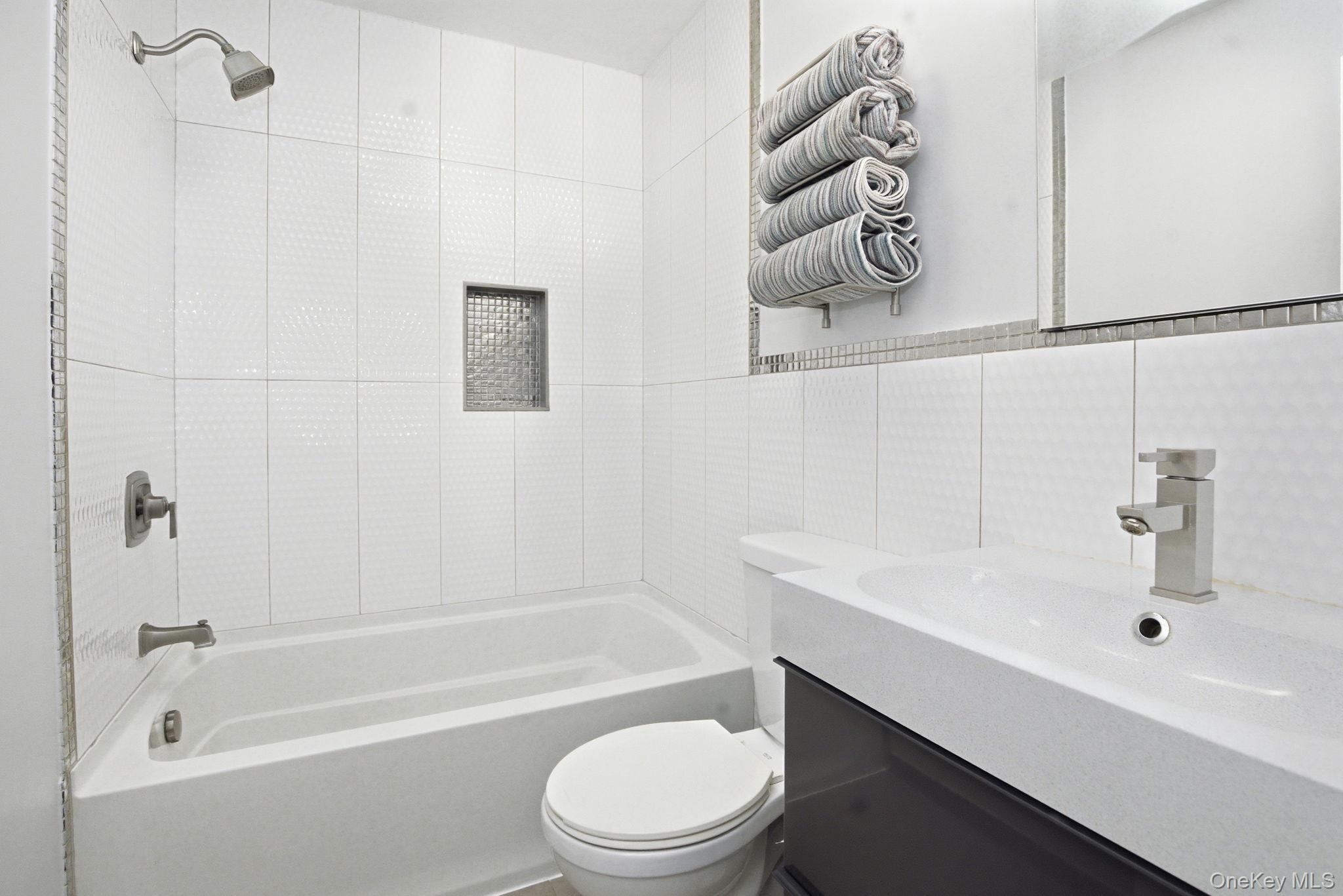 35 Deans Bridge Road Somers, NY 10589 - Photo 16 of 49 The updated full bath features crisp tilework, a sleek vanity, and a clean, modern finish.