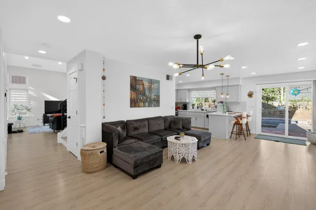 a kitchen with stainless steel appliances granite countertop a sink a stove a refrigerator cabinets and chairs