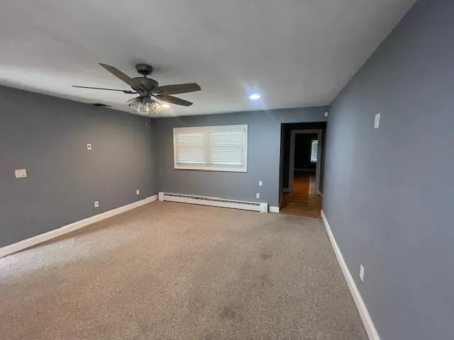 an empty room with a ceiling fan and window
