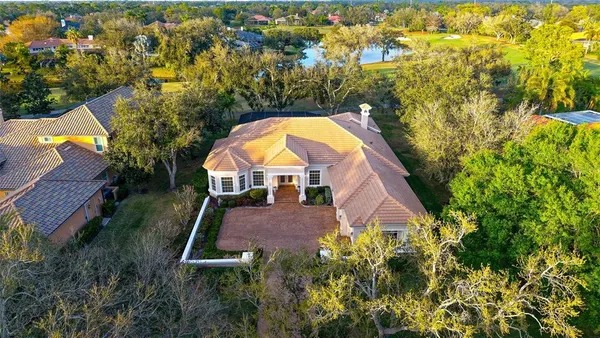 an aerial view of a house with swimming pool and green space