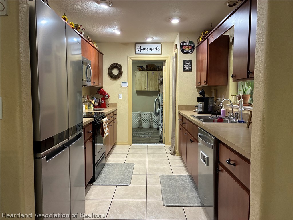 922 Breezy Road Lake Placid, FL 33852 - Photo 7 of 18 a large kitchen with stainless steel appliances kitchen island granite countertop a refrigerator and a sink
