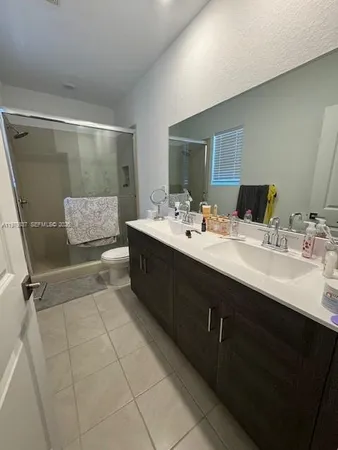 a en suite bathroom with a double vanity sink a mirror and a bathtub