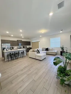 a living room with furniture and a dining table with kitchen view