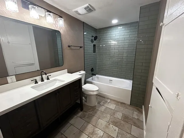 a bathroom with a double vanity sink toilet and shower