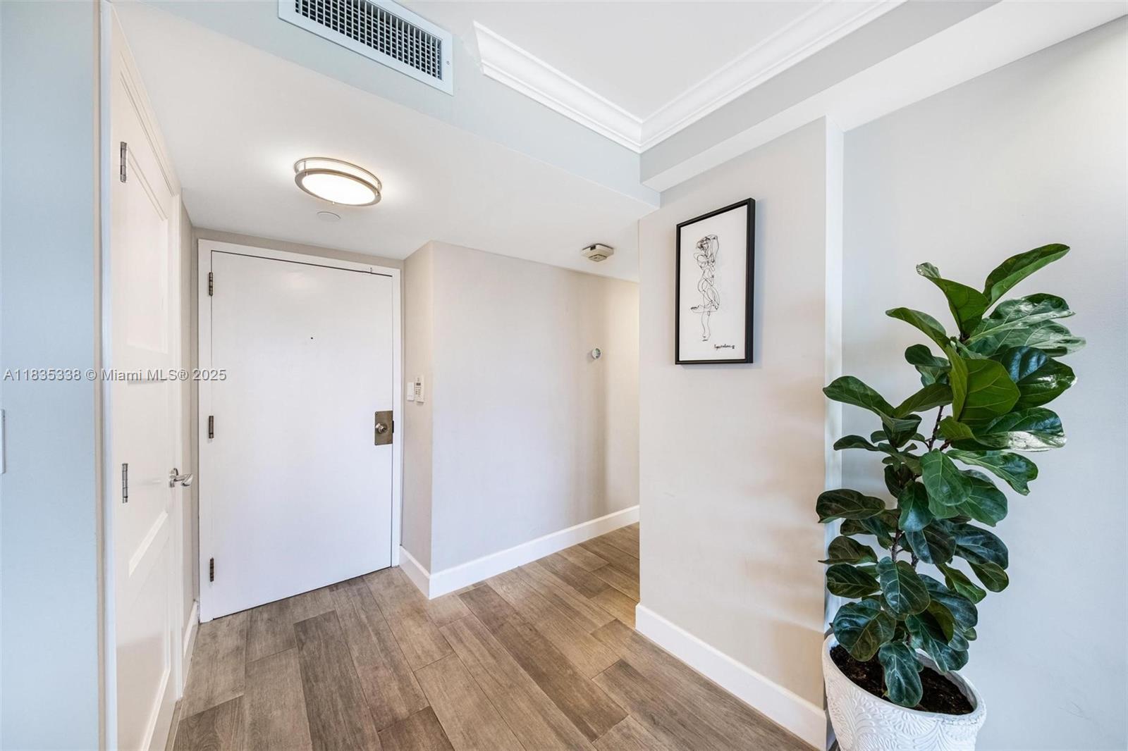 4000 Towerside Terrace, Unit 1507 Miami, FL 33138 - Photo 18 of 86 a view of a hallway with wooden floor and a potted plant